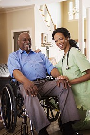 Nurse with man in wheelchair at home